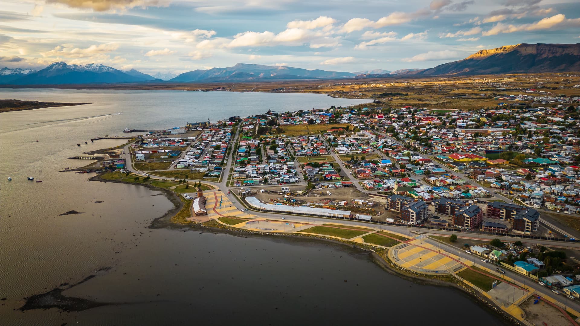 Aerial view of Puerto Natales, Chile town along the water with mountains in the background.